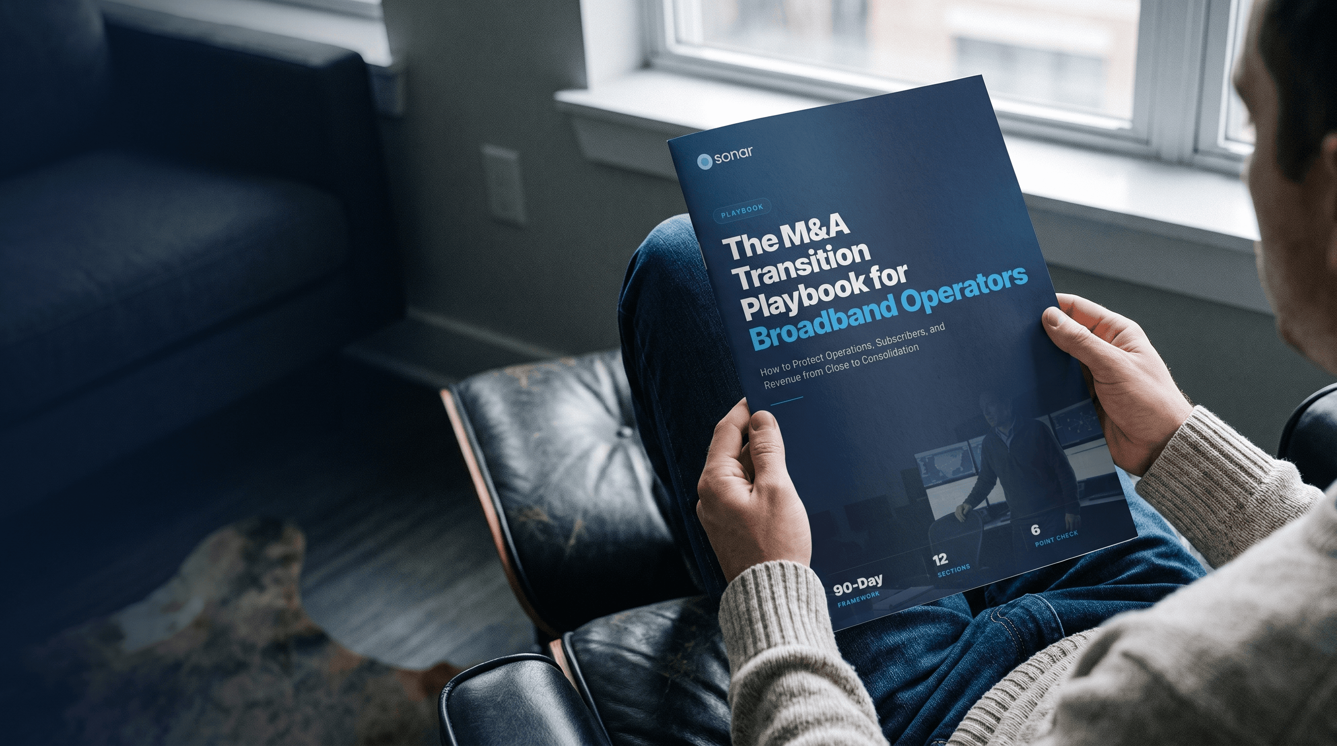 A person seated by a window reading a printed copy of the Sonar M&A Transition Playbook for Broadband Operators.
